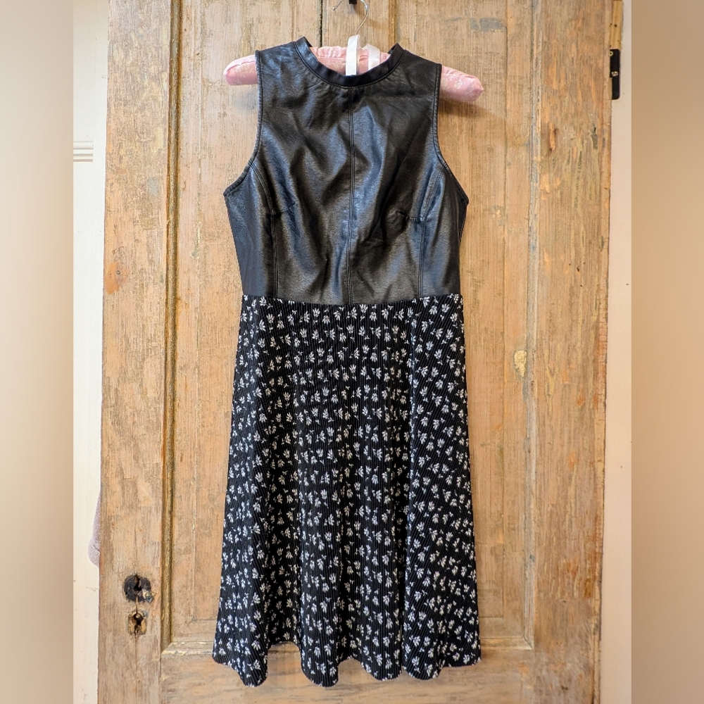 Tailored black dress with faux leather bodice and pleated skirt